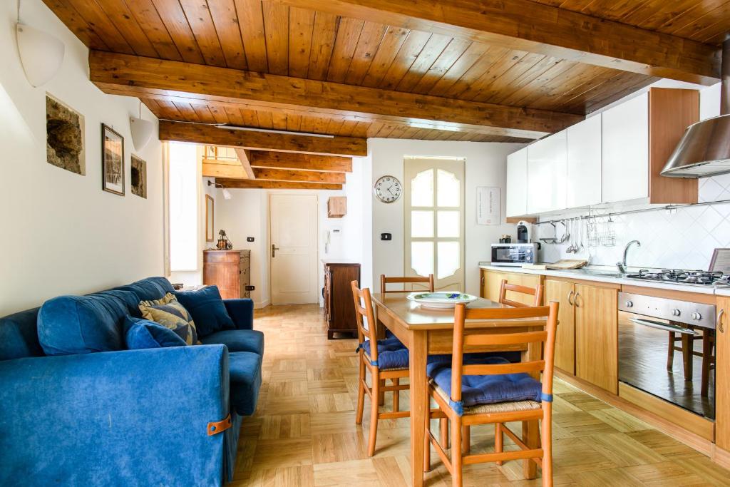 uma cozinha e sala de estar com uma mesa e um sofá azul em RESIDENZA SANTA LUCIA em Nápoles
