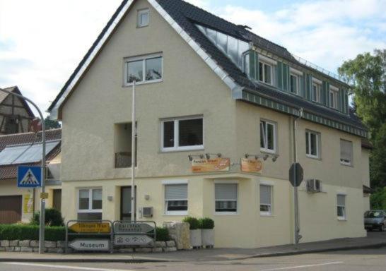 a large house with a roof on a street at Pension Wauri , Ferienwohnung ' SCHÖNBUCH ' , zweites Obergeschoss in Waldenbuch