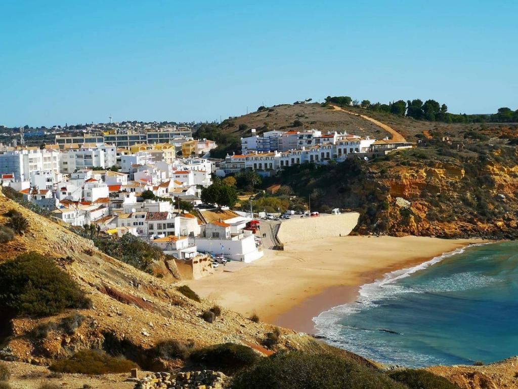 a view of a beach with white buildings on a hill at Amarguinha in Burgau