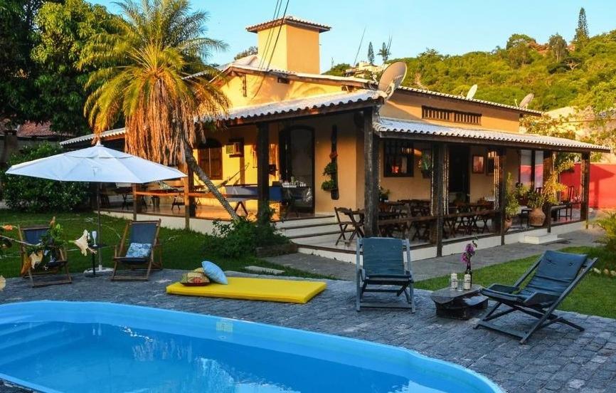 una casa con piscina frente a una casa en Pousada Bela Casa Geribá, en Búzios