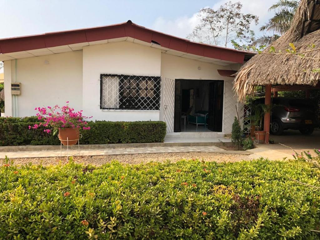 uma pequena casa branca com um telhado vermelho em Cabaña Coveñas em Coveñas