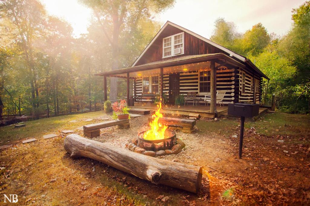 una hoguera frente a una cabaña de madera en Nolichuckey Bluffs Bed & Breakfast Cabins, en Greeneville
