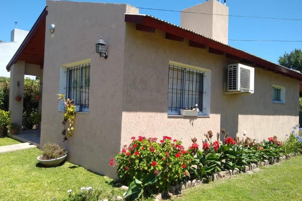 uma casa com flores em frente em Cabaña Villa Allende em Villa Allende