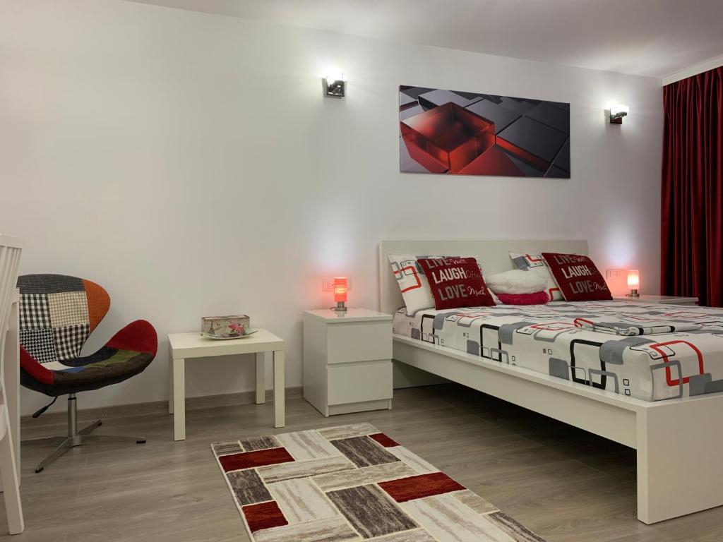 a bedroom with a bed and a chair in it at Mery Apartment in Galaţi