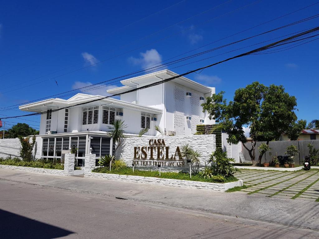 une maison blanche avec un panneau devant elle dans l'établissement Casa Estela Boutique Hotel & Cafe, à Calapan