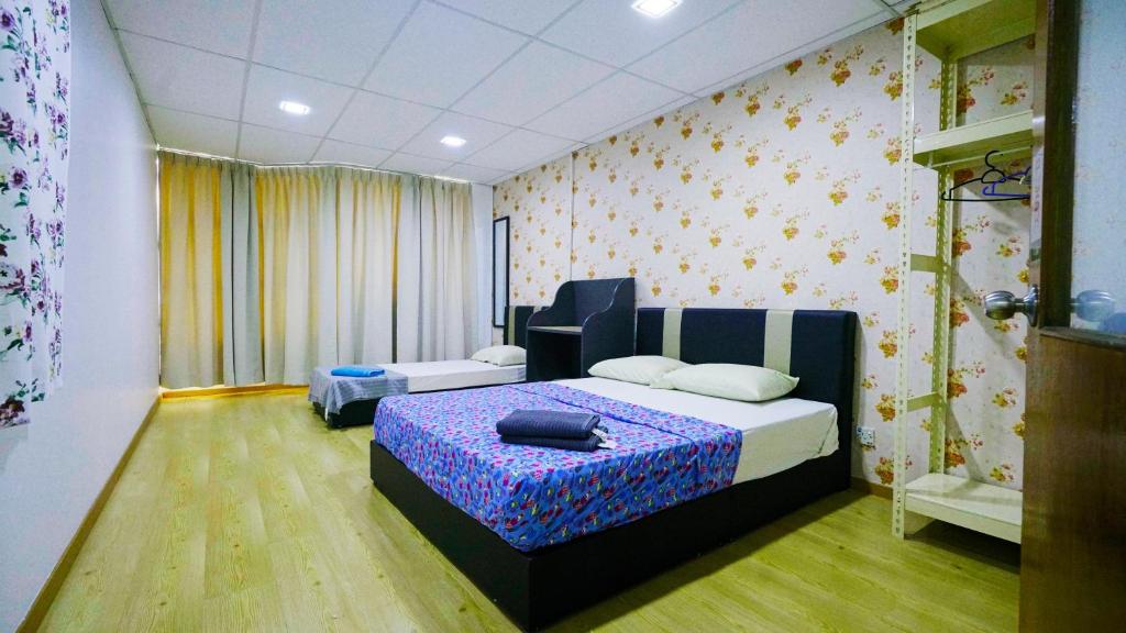 een slaapkamer met een bed met een blauwe en paarse deken bij Pak Long Shoplot Homestay in Shah Alam