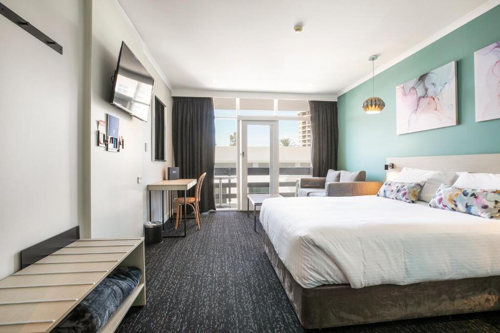 Adelaide的住宿－Nightcap at Watermark Glenelg，配有一张床和一张书桌的酒店客房