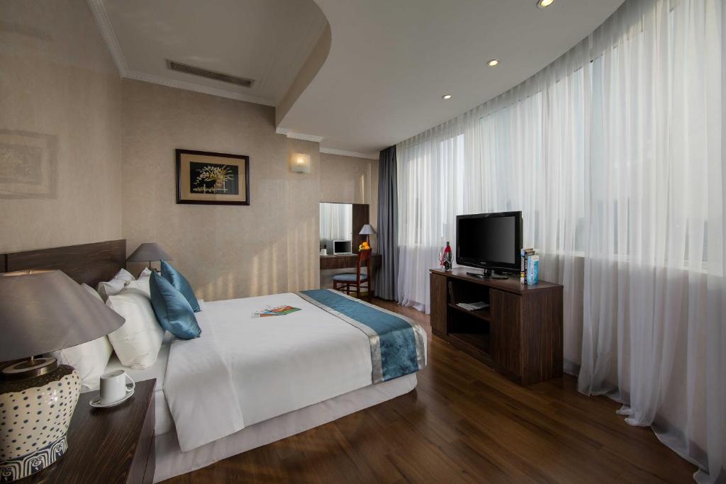 a hotel room with a bed and a television at Danly Hotel in Hanoi