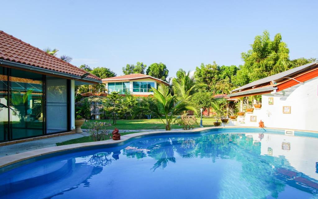 a swimming pool in front of a house at Tina's Living Paradise - Guesthouses with private pool in Ban Phe