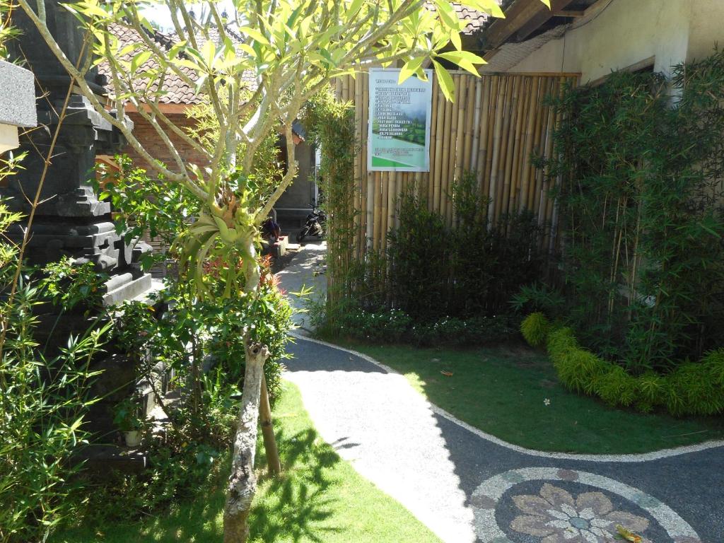 a garden with a tree in the middle of a walkway at Dika Homestay in Sidemen
