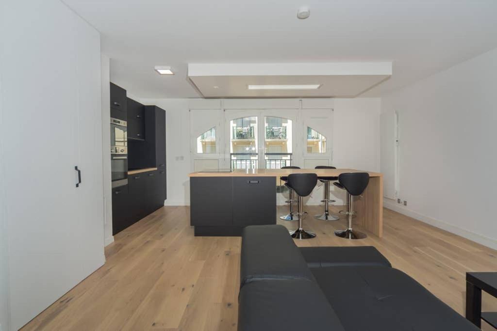 un salon avec un canapé noir et une table dans l'établissement LOVELY APARTMENT CLOSE TO A BIG SHOPPING MALL, à Serris