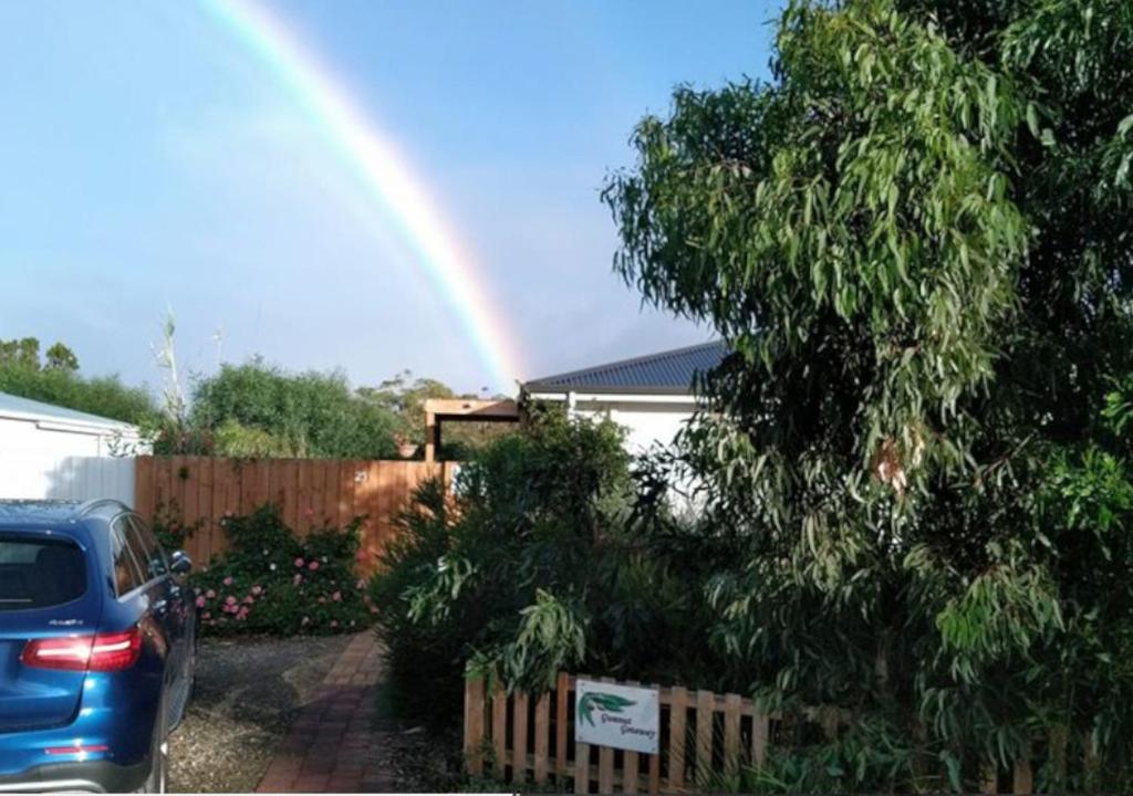 a rainbow in front of a house with a car at Gumnut Getaway BnB in Goolwa North