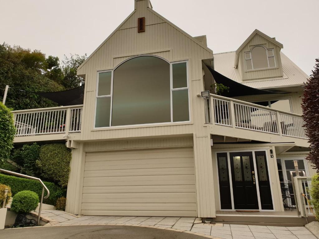 a house with a balcony and a garage at Tui2 Macandrew Bay in Dunedin