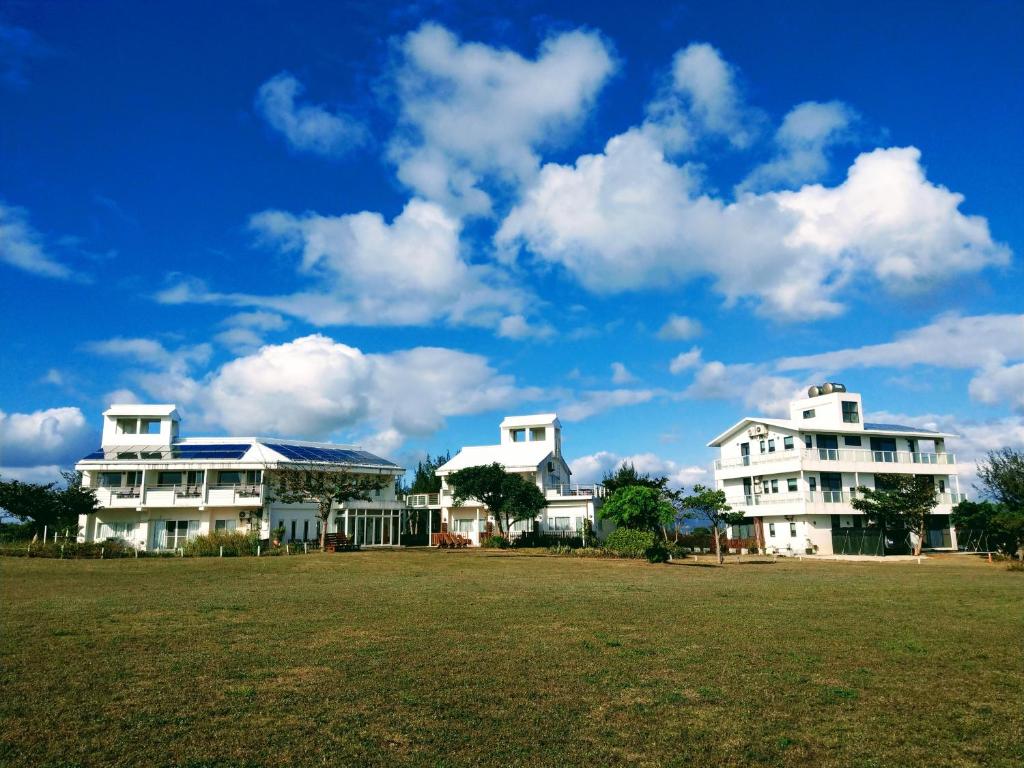 a group of white houses with a green field at Kenting COMIC B&amp;B in Hengchun South Gate