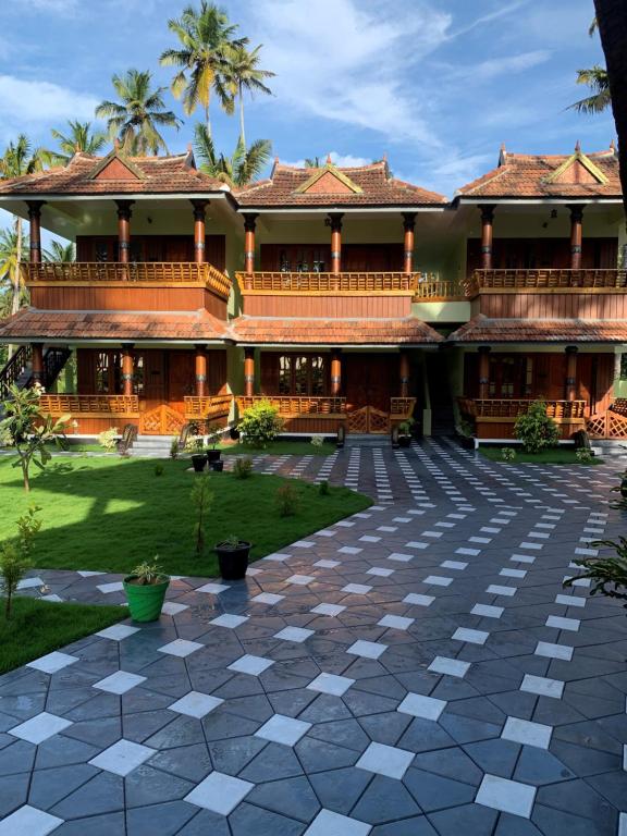 a building with a courtyard in front of it at Royal KazBay Beach Resort in Varkala