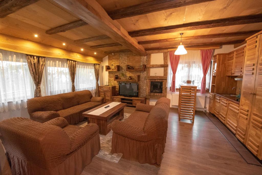 ein Wohnzimmer mit einem Sofa, Stühlen und einem TV in der Unterkunft Eko-FIS Vlašić in Vlasic