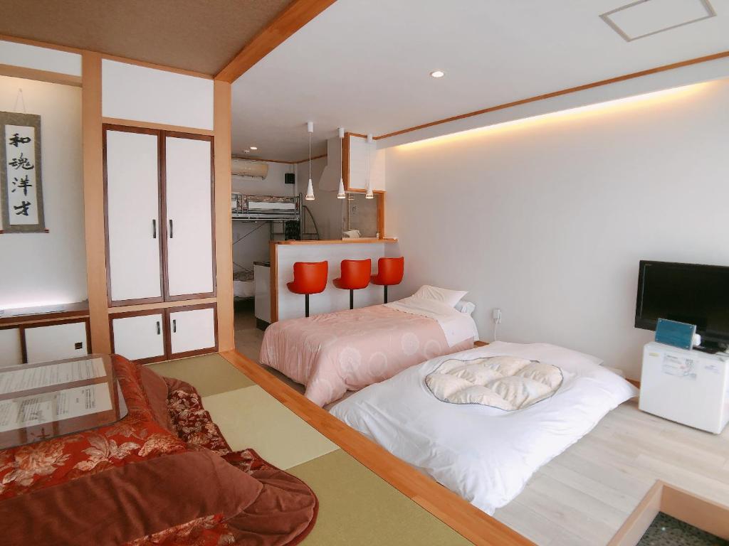 a room with two beds and a tv in it at PittINN in Goshogawara