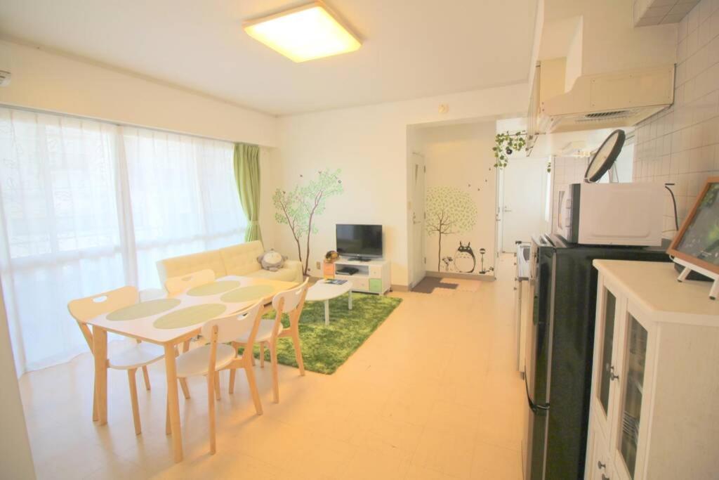 eine Küche und ein Wohnzimmer mit Tisch und Stühlen in der Unterkunft 沖縄ライフインゼファー Okinawa Totoro House in Tōbaru