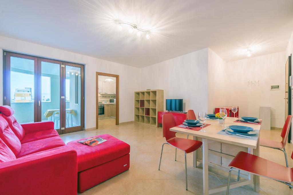 uma sala de estar com um sofá vermelho e uma mesa em GoodStay Archimede Apartment em Lecce