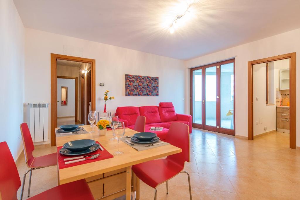 salon z czerwoną kanapą i stołem w obiekcie GoodStay Archimede Apartment w mieście Lecce