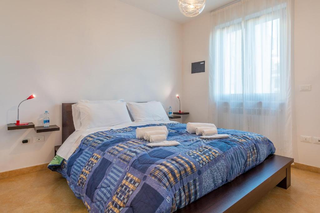sypialnia z dużym łóżkiem z dwoma ręcznikami w obiekcie GoodStay Archimede Apartment w mieście Lecce