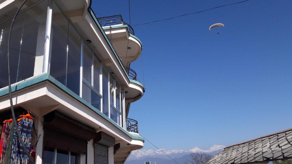 a building with a kite flying in the sky at Lake View Lodge Sarangkot in Pokhara