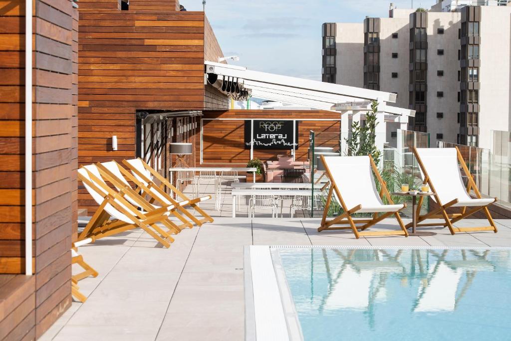 un patio en la azotea con sillas y una piscina en INNSiDE by Meliá Zaragoza, en Zaragoza