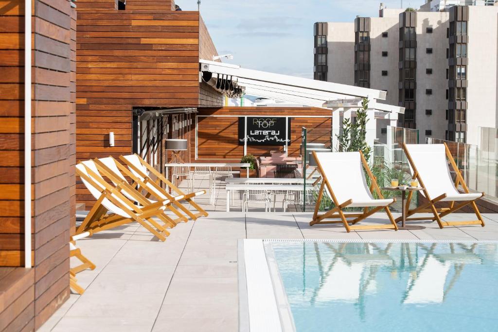 a rooftop patio with chairs and a pool at INNSiDE by Meliá Zaragoza in Zaragoza