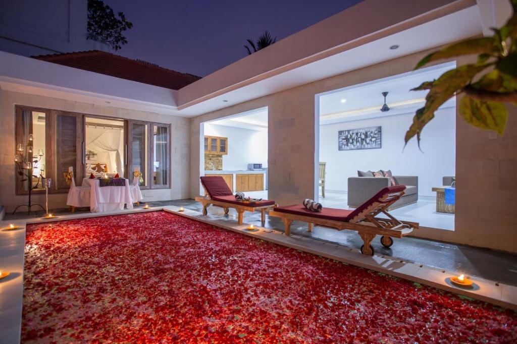 a living room with a large red rug at The Awandari Villas Seminyak - CHSE Certified in Seminyak