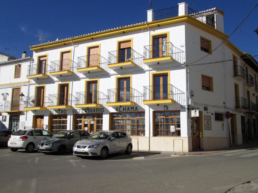 a white building with cars parked in front of it at Apartamento Terranova Esquina Placeta in Alhama de Granada