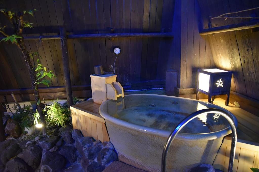 a large bath tub in a garden with a candle at Dormy Inn Akihabara in Tokyo