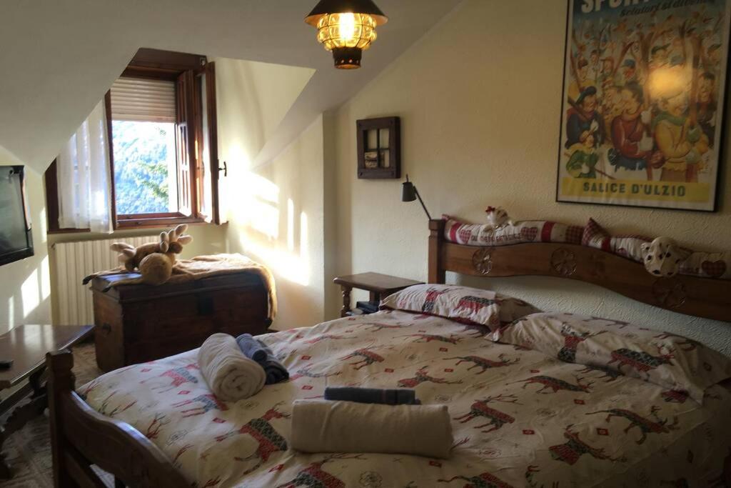een slaapkamer met een bed met knuffels erop bij Maison des Alpes mansarda in Sauze dʼOulx