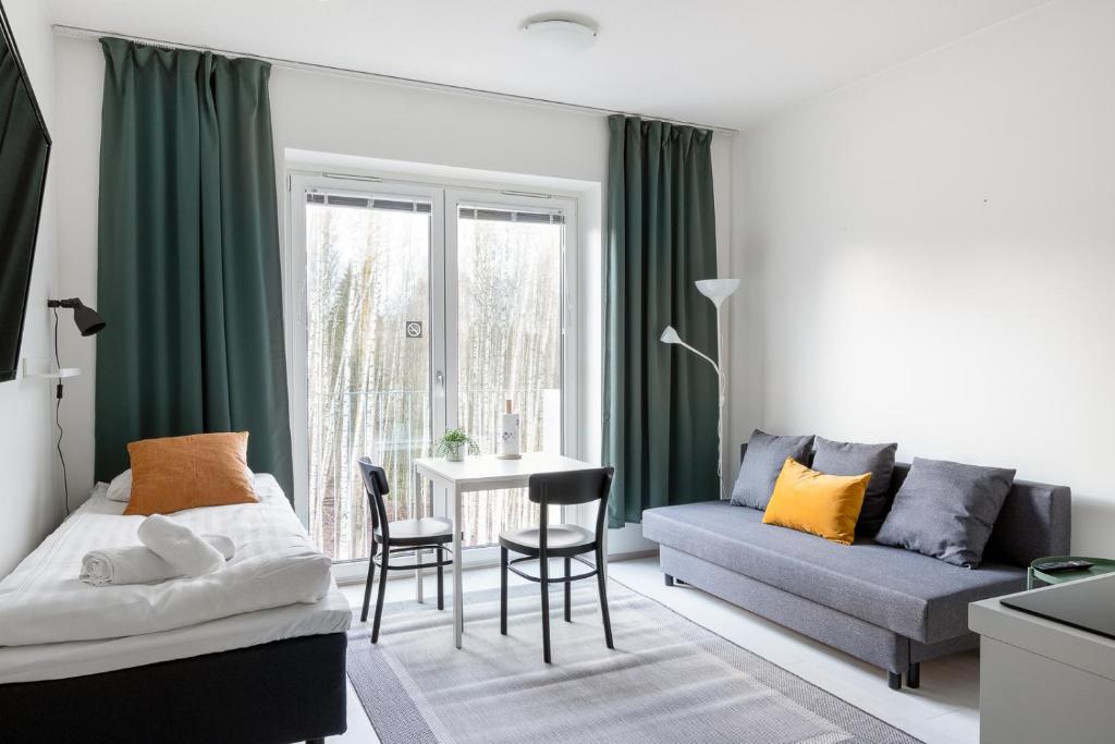 ein Wohnzimmer mit einem Sofa und einem Tisch in der Unterkunft Hiisi Homes Vantaa Kaivoksela in Vantaa