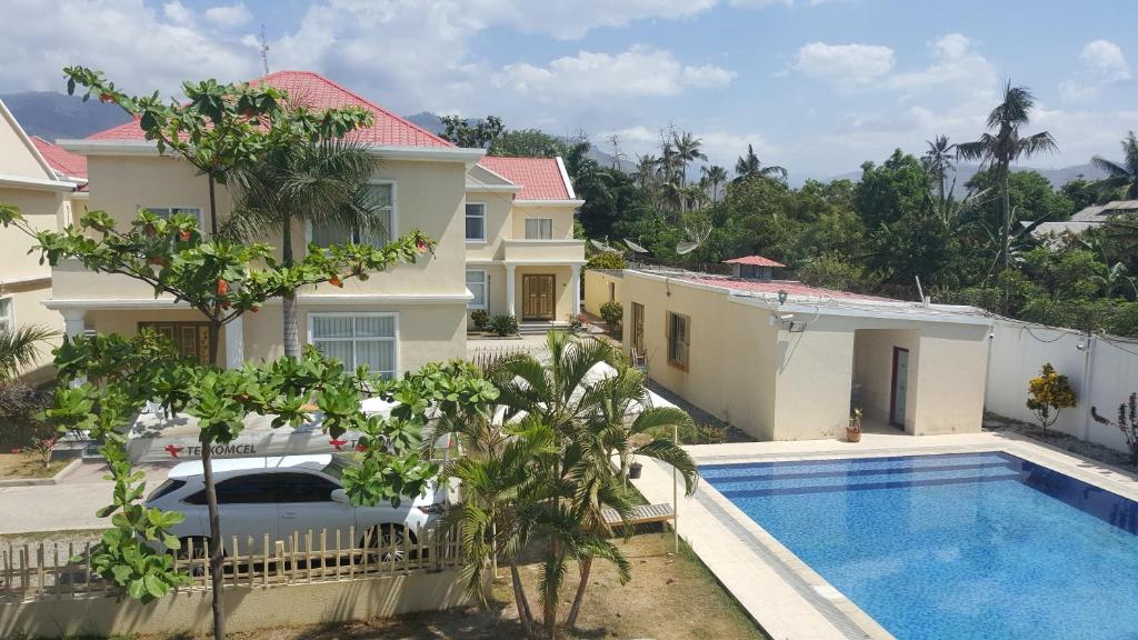 uma villa com uma piscina e uma casa em Beach Garden Hotel em Díli