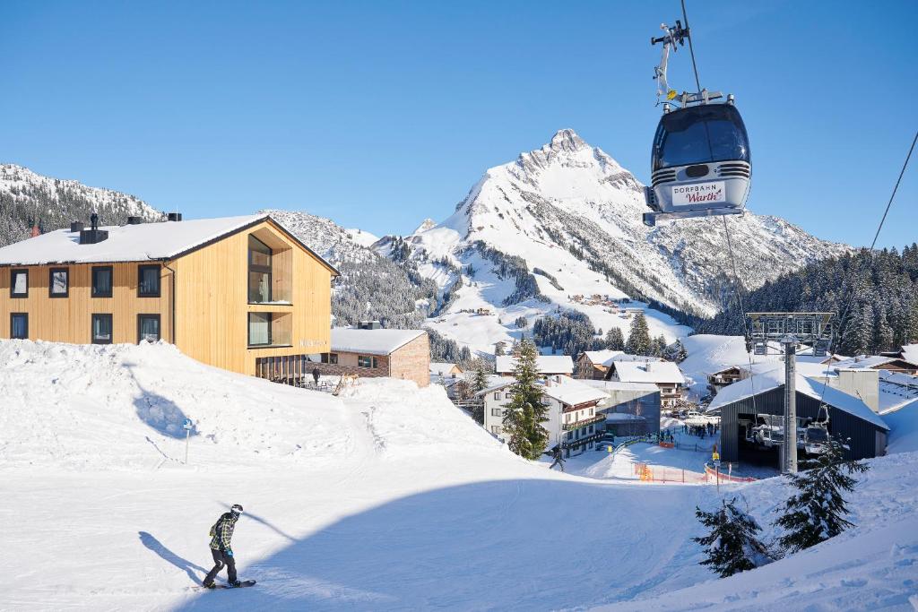 eine Person auf Skiern im Schnee in der Nähe eines Skilifts in der Unterkunft Warth52-W52 Apartments in Warth am Arlberg