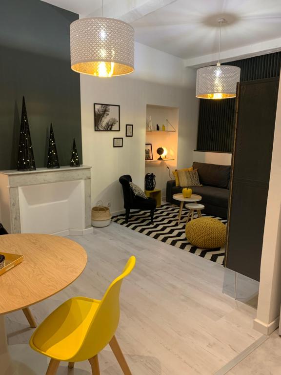 a living room with a table and yellow chairs at SOO and CO SooHome in Marseille