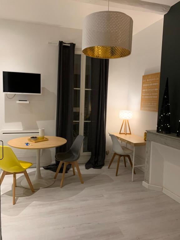 a living room with a table and chairs and a tv at SOO and CO SooHome in Marseille