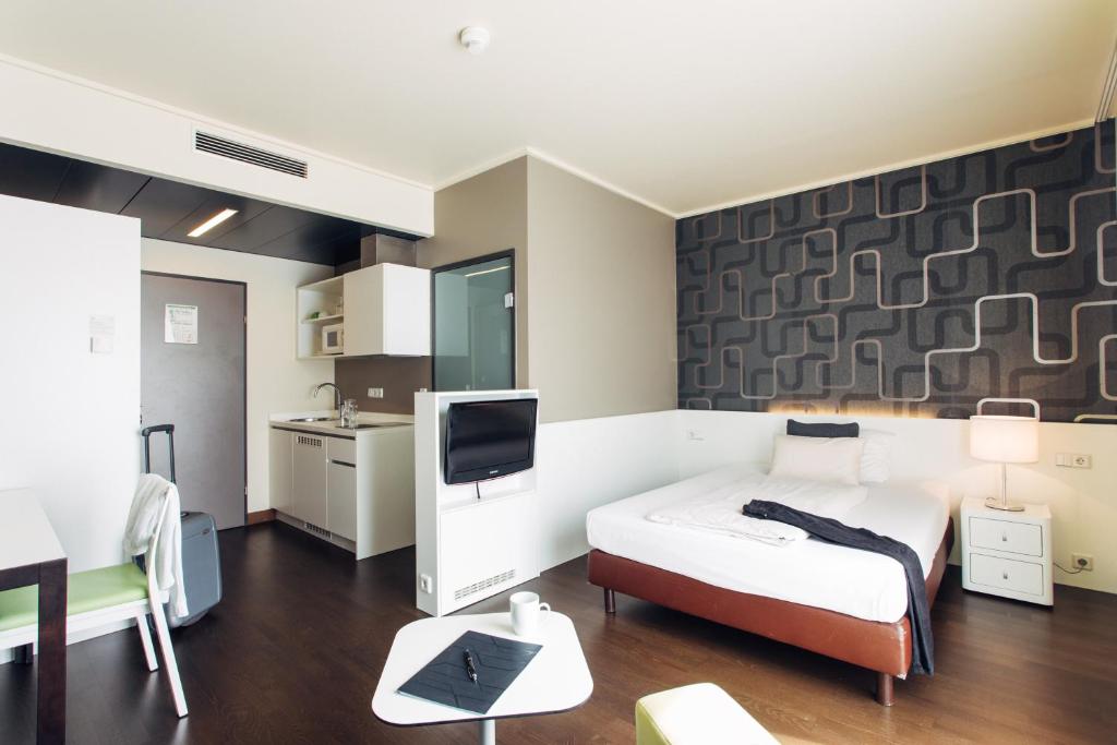 a hotel room with a bed and a tv at harry's home hotel & apartments in Linz