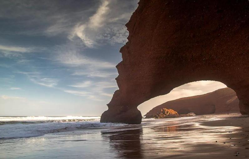 a view of a beach with a rock formation at Résidence Elgzira in Mirleft