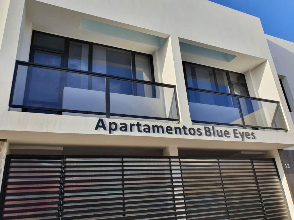 a building with a sign that reads apparateurs blue eyes at APARTAMENTOS BLUE EYES in Castillo del Romeral