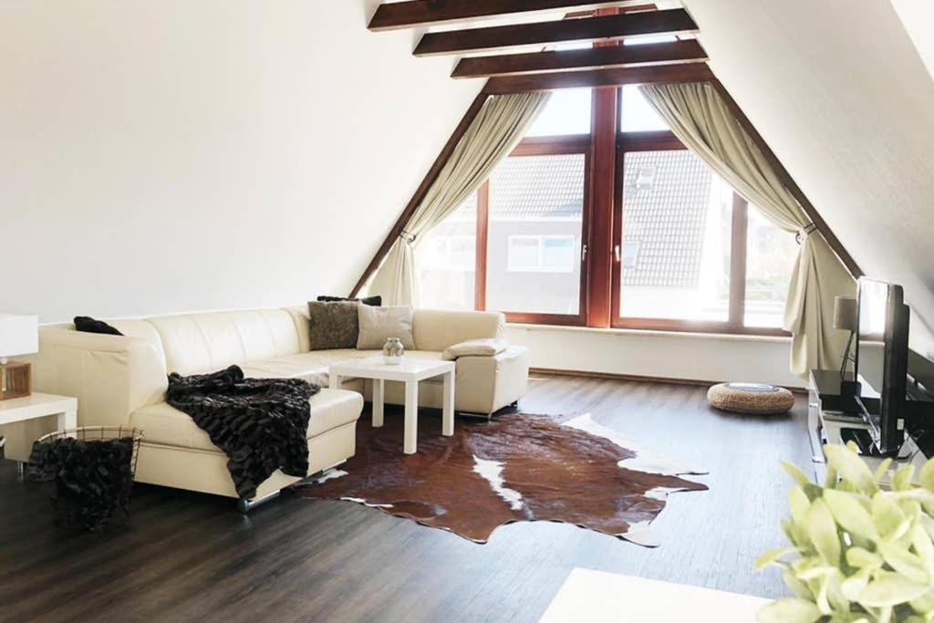 a living room with a white couch and a table at Ferienwohnung Haus Ruhrgebiet in Mülheim an der Ruhr