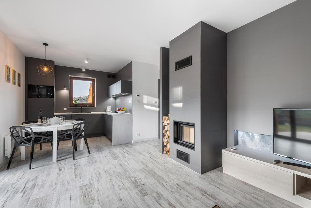 a kitchen and dining room with a table and a tv at Apartament Strumień in Jaworki