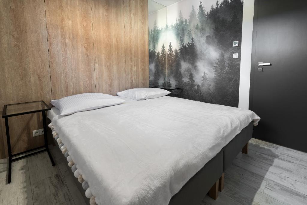 duże łóżko w pokoju z obrazem na ścianie w obiekcie Apartament Strumień w mieście Jaworki