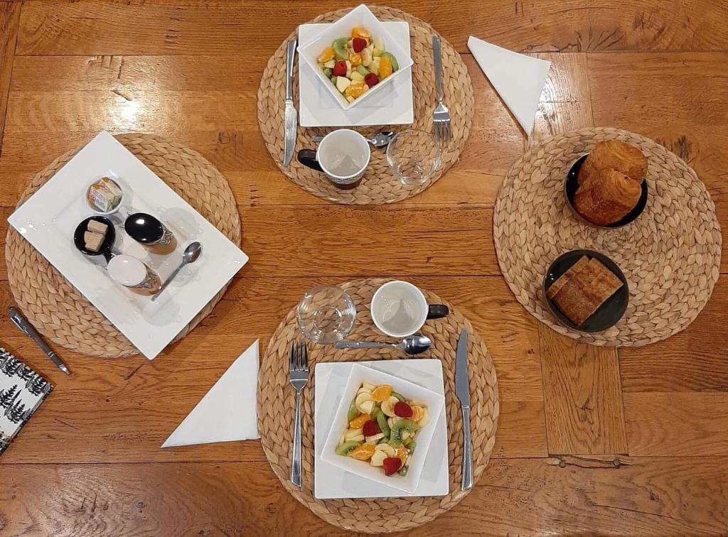 tres platos de comida en una mesa de madera en L'Ostal de l'Antougnou, en Cavanac