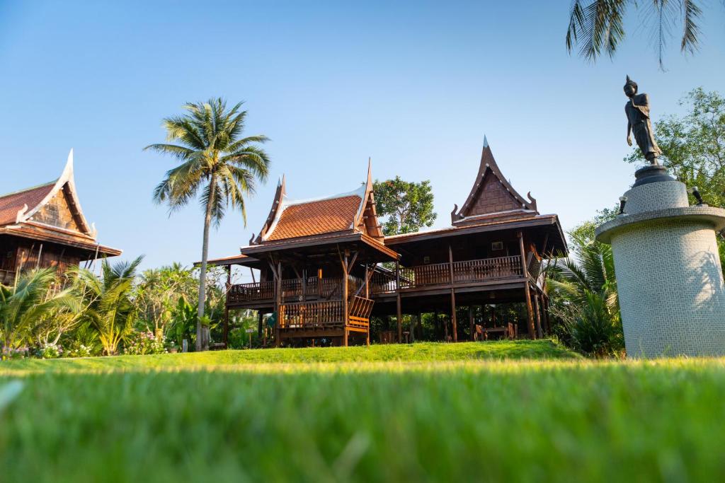 un bâtiment avec une statue devant lui dans l'établissement Maikaew Damnoen Resort, à Damnoen Saduak