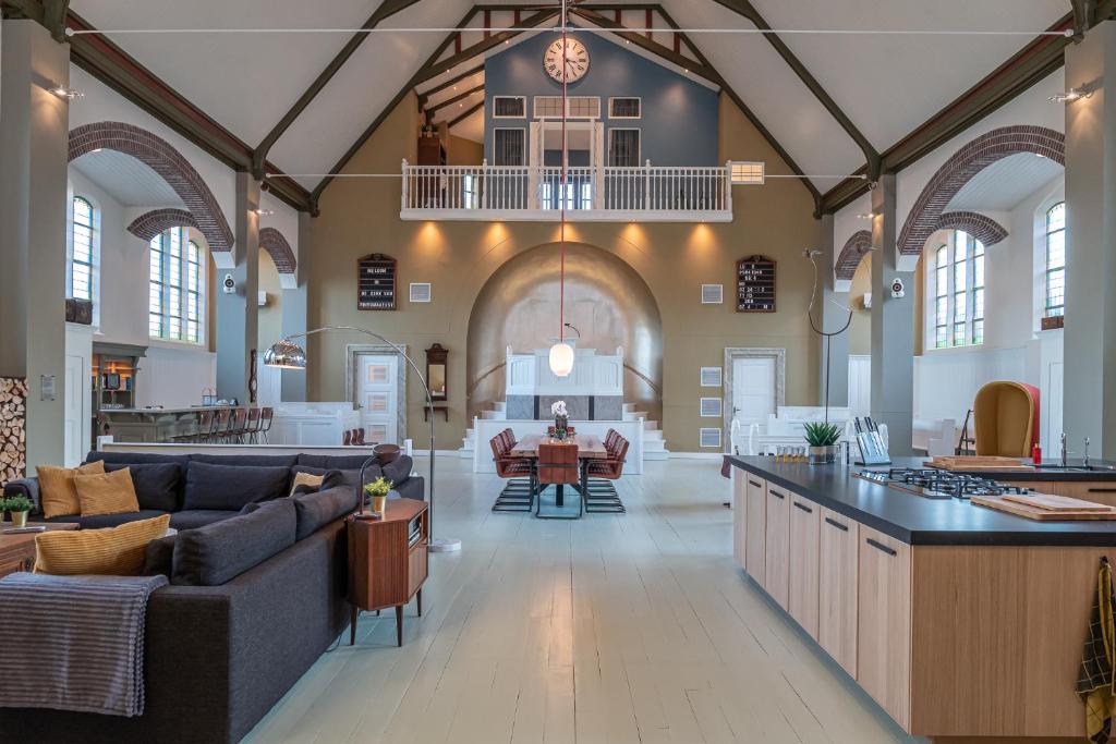 a large room with a kitchen and a living room at Church conversion for a unique stay and experience in Rinsumageest