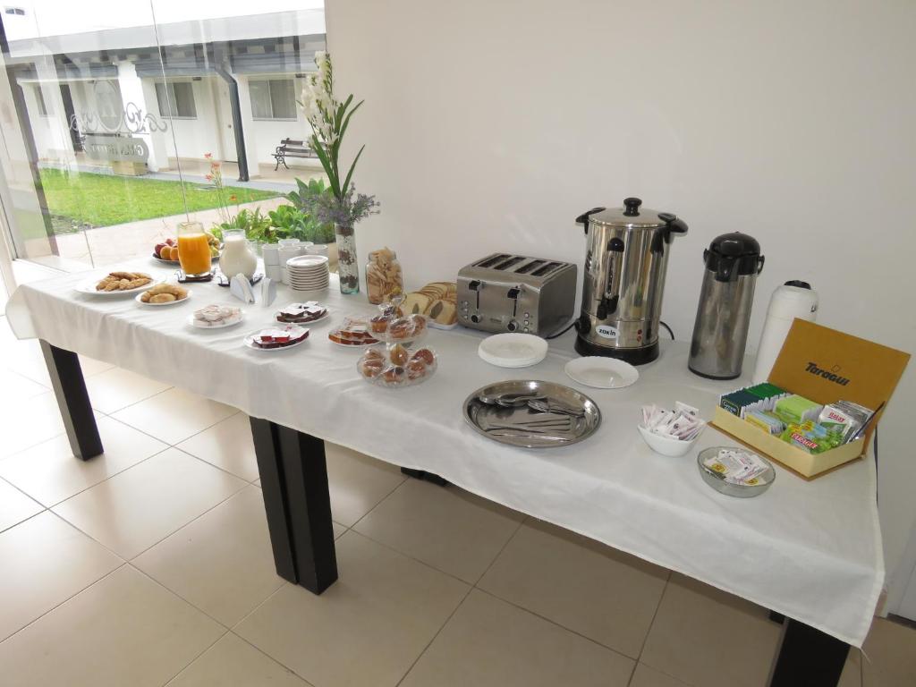 una mesa blanca con comida encima en GRAN HOTEL CURUZU CUATIA en Curuzú Cuatiá