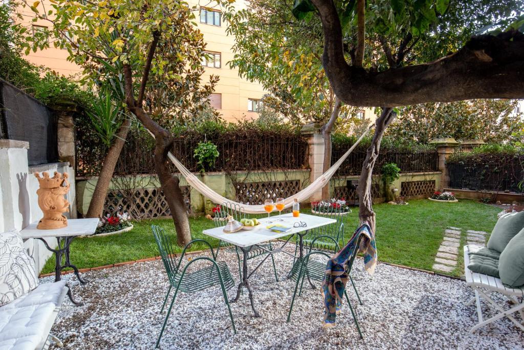 a hammock in a garden with a table and chairs at SECRET GARDEN - Amazing Loft in The Imperial Rome in Rome