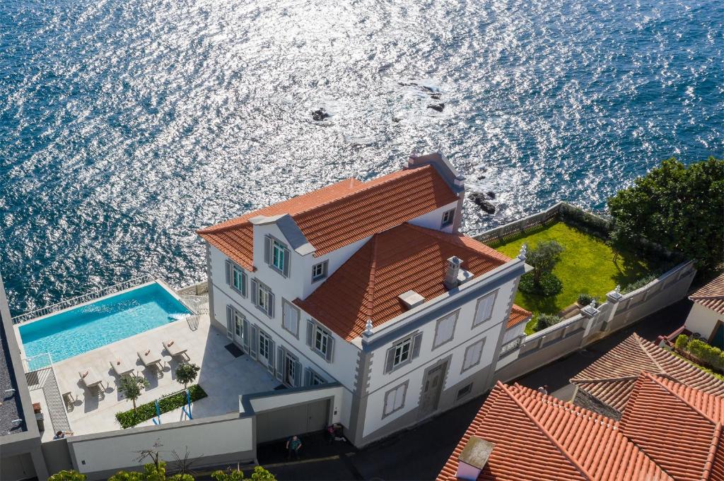 eine Luftansicht eines Hauses neben dem Meer in der Unterkunft Luxury Barreirinha House old town by HR MADEIRA in Funchal