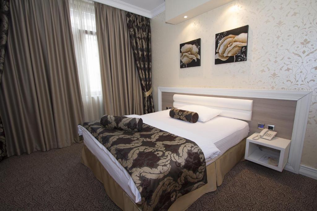 ein Hotelzimmer mit einem Bett und einem Telefon in der Unterkunft Hotel Talija in Banja Luka